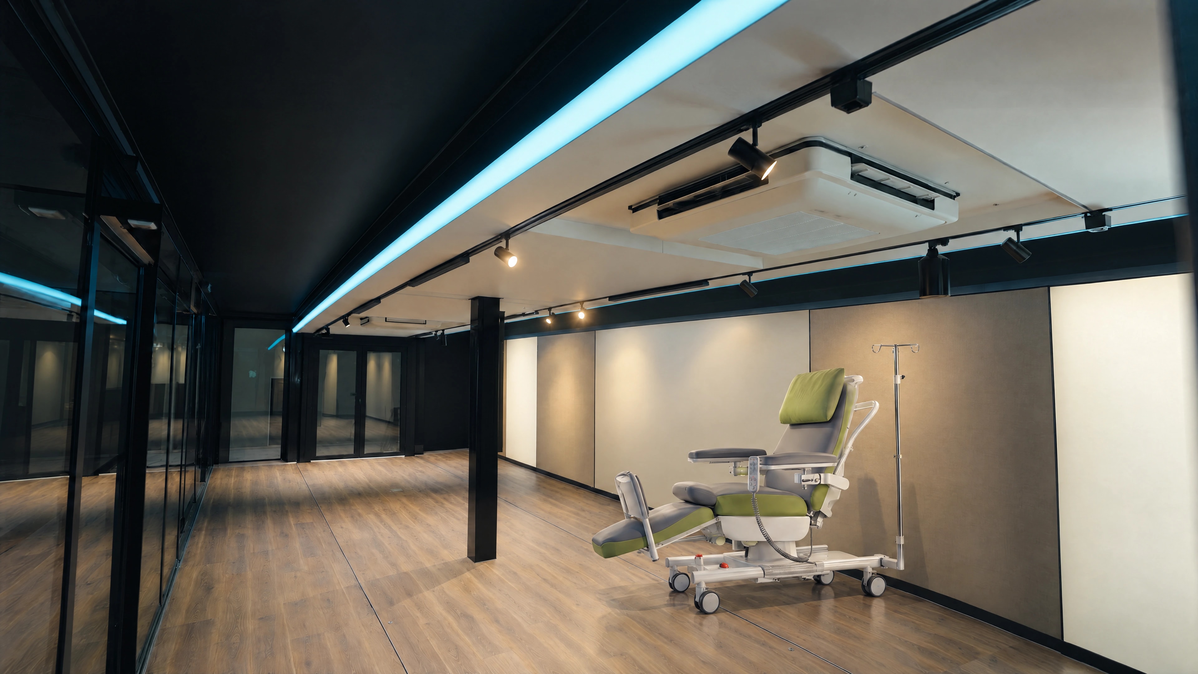 Puesto ilustrativo con un único sillón de tratamiento junto a una pared neutra, con un poste central negro, suelo despejado y una abertura acristalada trasera, en una referencia de plataforma expandible.
