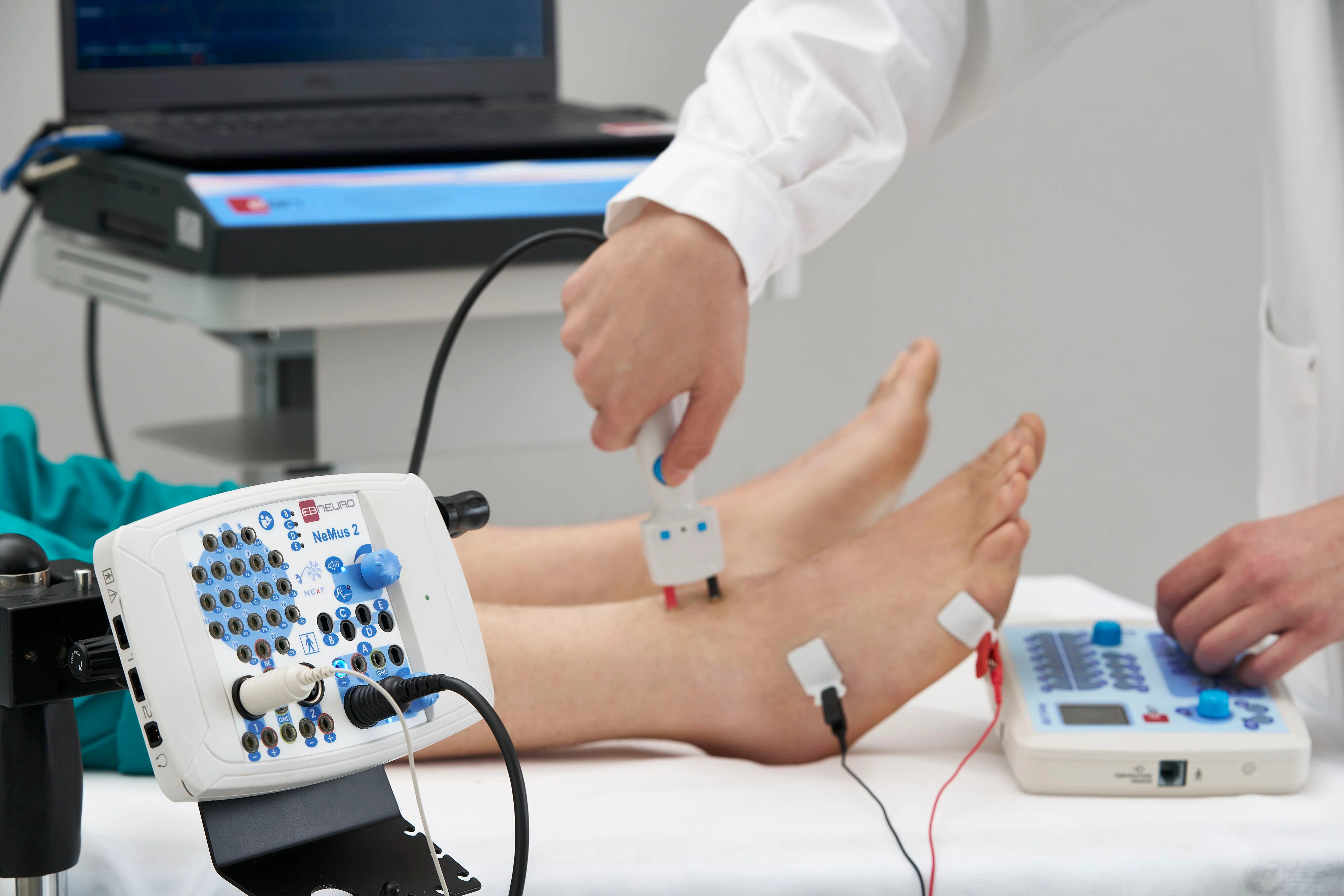 Un profesional sanitario realiza un estudio de conducción nerviosa en la parte inferior de la pierna de un paciente con un sistema EB Neuro NeMus2.