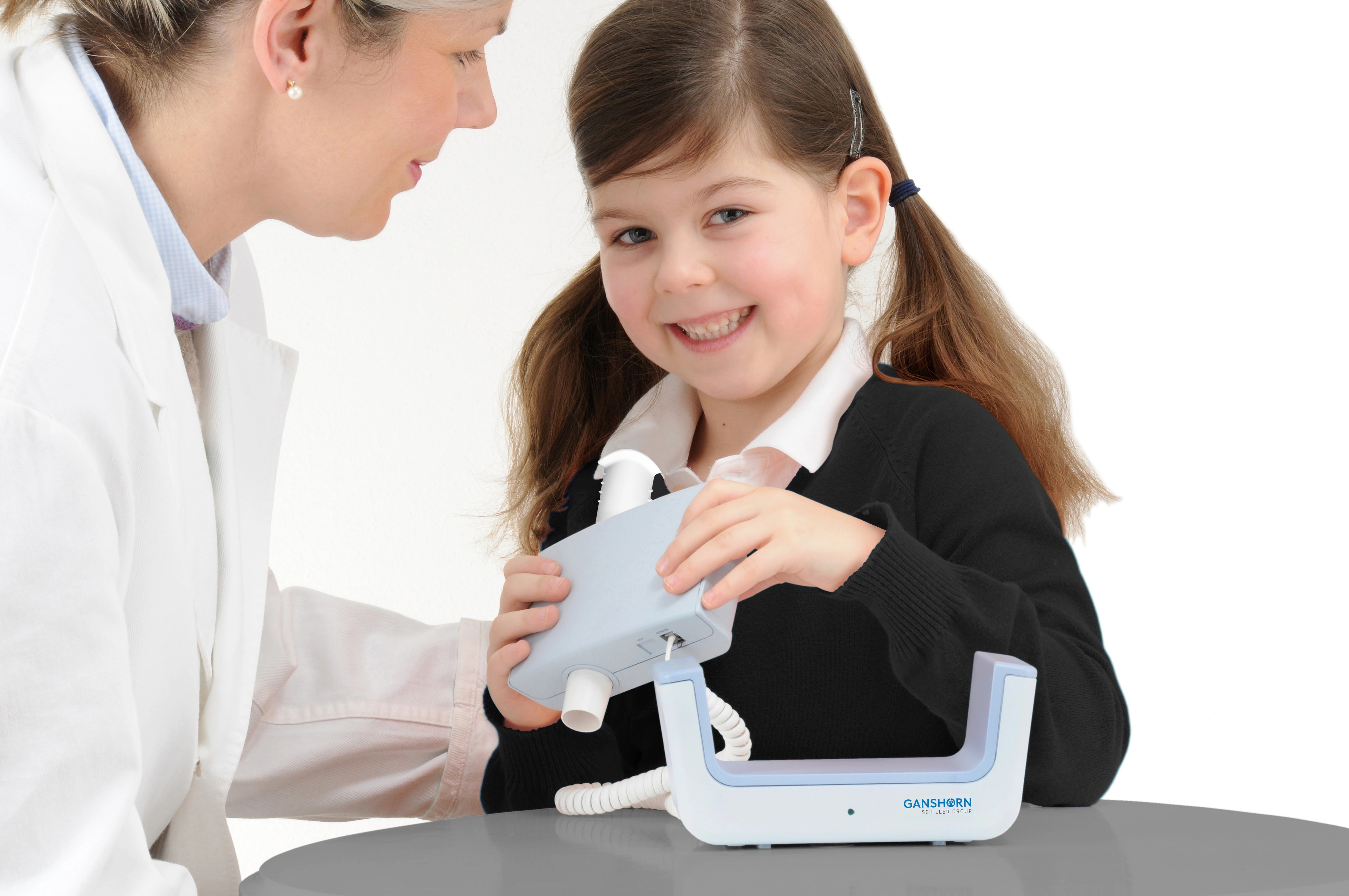 Un profesional sanitario ayuda a un niño a preparar un sensor GANSHORN SpiroScout para una demostración de espirometría.