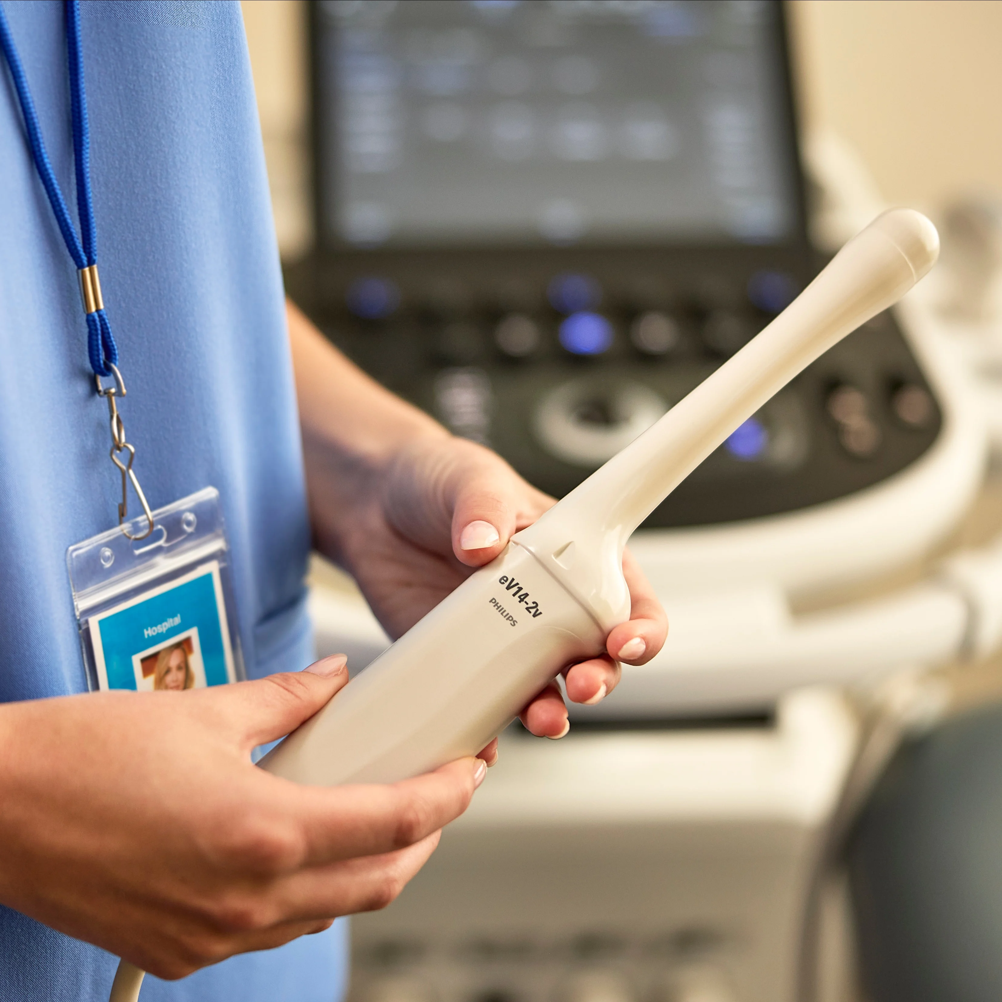 Un profesional sanitario sostiene un transductor ecográfico Philips eV14-2v, con el ecógrafo al fondo.